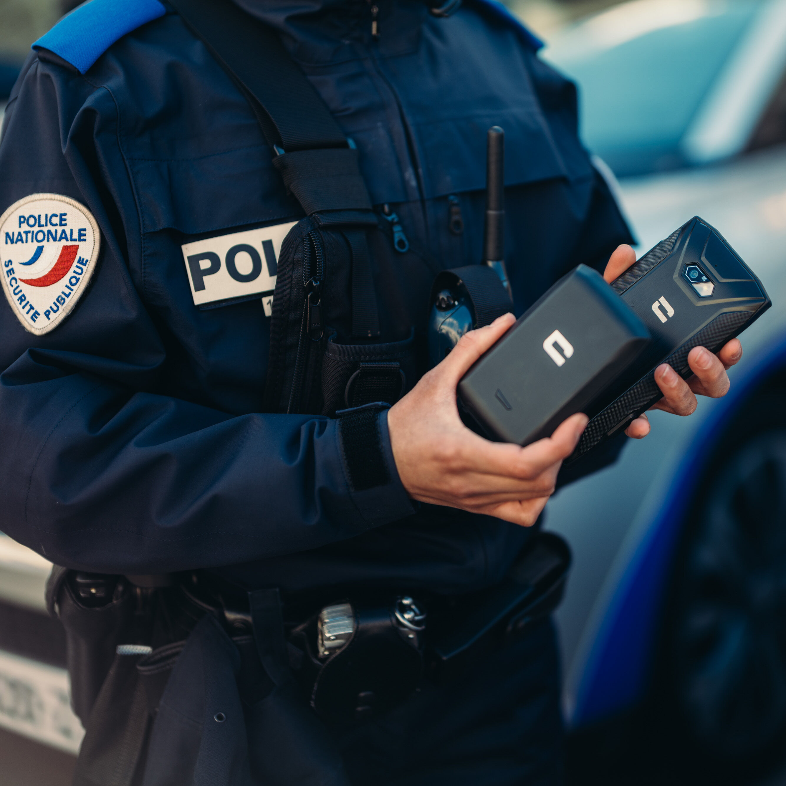 Agente de policía con smartphone Crosscall y batería externa X-POWER
